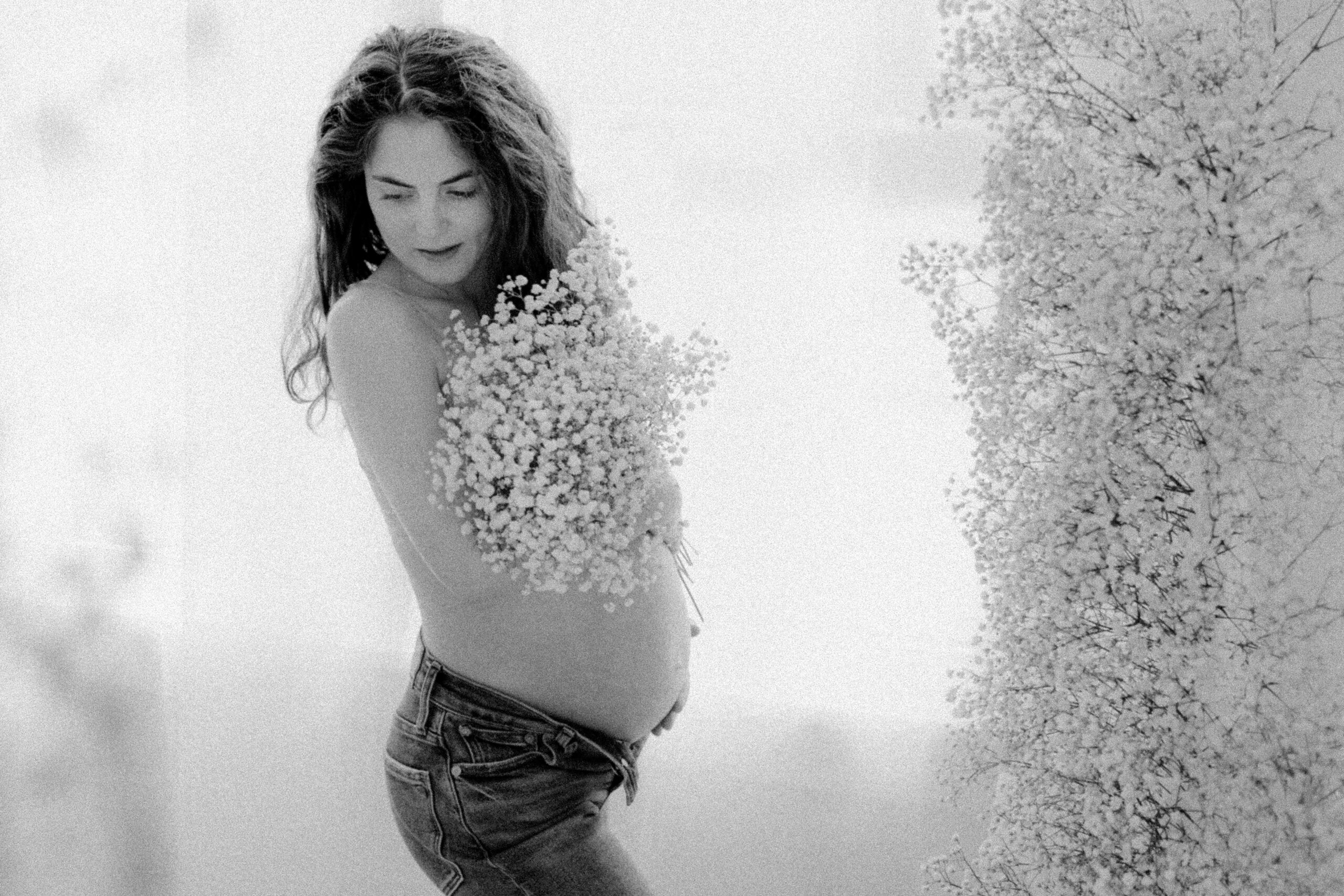 black and white image of pregnant woman with flowers