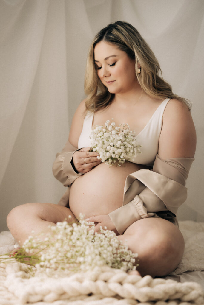 an intimate maternity session with flowers in a Rochester NY maternity studio