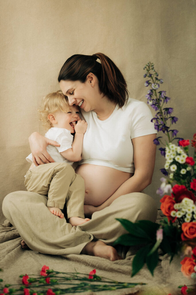 a sweet moment between a Mom and Son for maternity photo session in a Rochester NY studio