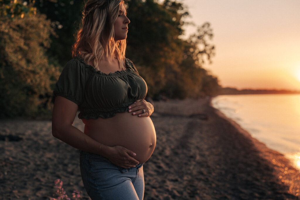 maternity photo wearing jeans and a crop top